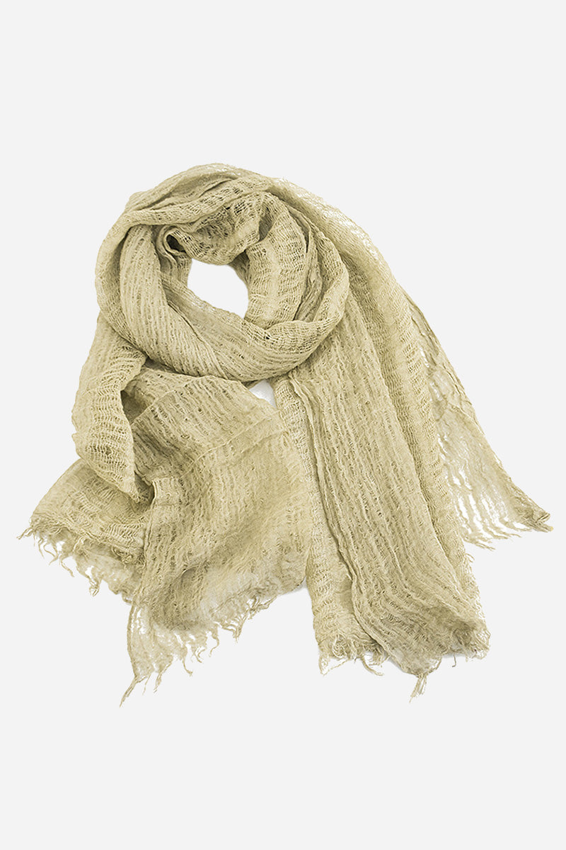 A light beige, loosely woven scarf with frayed edges, made from ultra-breathable linen, is displayed against a white background. The Lightweight Linen Scarf from looselyboho appears soft and lightweight, exuding artisanal charm and suitable for casual wear.