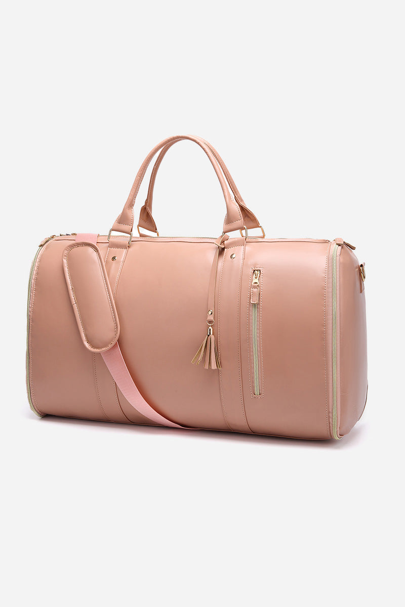 The Windbreaker Jacket's Smart No-Wrinkle Foldable Travel Bag is a light pink duffel made from waterproof PU leather, featuring gold zippers, two carrying handles, and a detachable shoulder strap. Its smooth finish is complemented by tassel accents on the front zipper, all set against a plain white background.