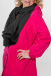 A person wears the iconic BARBARA PINK WINDBREAKER OUTFIT with black buttons and a black scarf by looselyboho. Visible details include a gold ring on their hand placed on their hip. This piece is part of the limited edition collection, making it truly special against the plain white background.