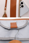 Close-up images showcase The Windbreaker Jacket's waterproof PU leather travel bag in white with brown accents. The top half features an open zippered compartment with a smartphone partially inside. The bottom half reveals the interior, complete with a built-in hook for hanging, demonstrating its smart no-wrinkle foldable travel bag design.