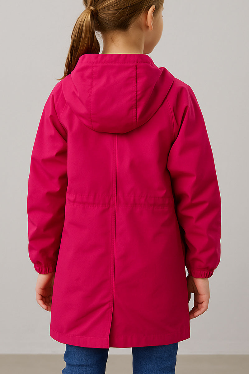 A child faces away from the camera in blue jeans and the looselyboho Bright Berry Kids’ Windbreaker, a berry pink water-resistant jacket with long sleeves, an elastic waistband, and a plain light gray background.